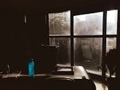 这间光线昏暗的办公室有大窗户，办公桌上洒满自然光