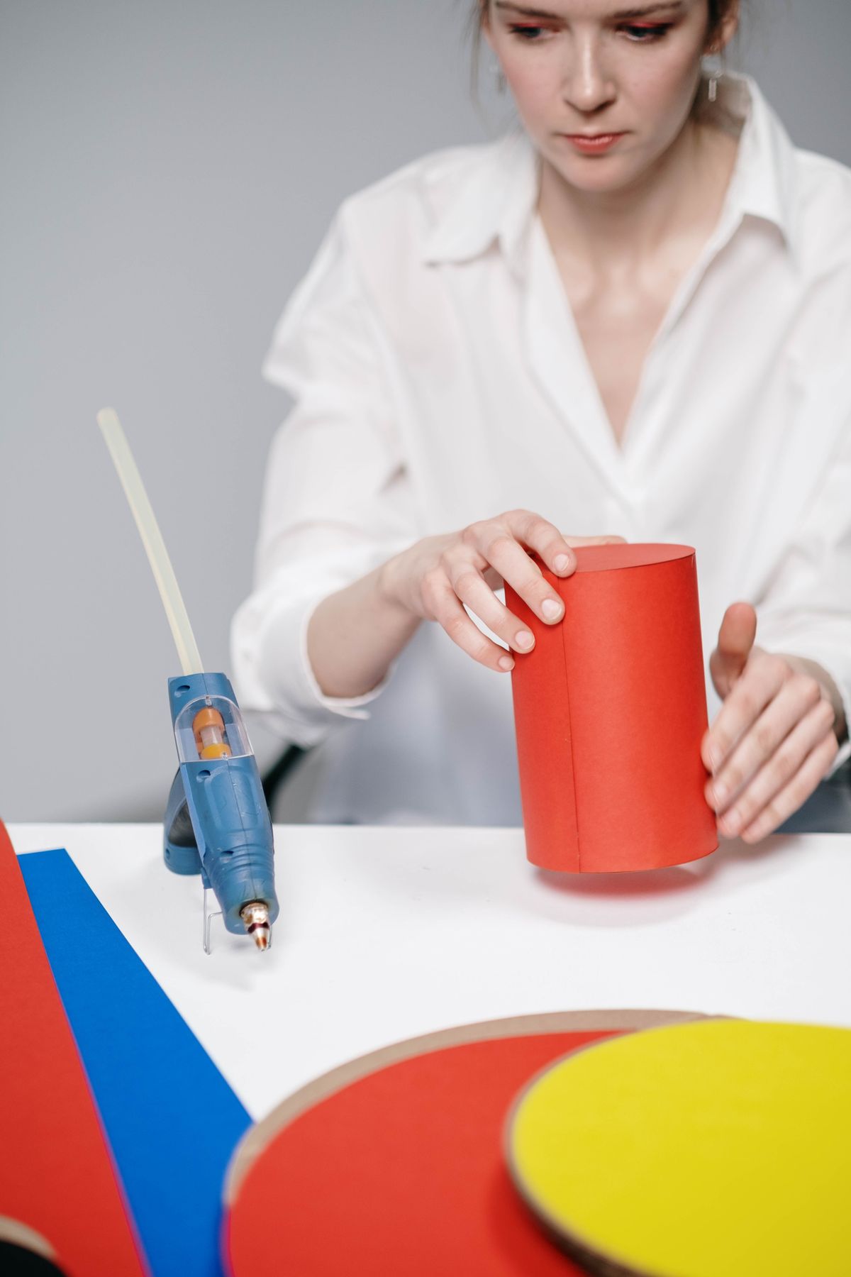 Woman decorating a colorful keepsake box using a hot glue gun