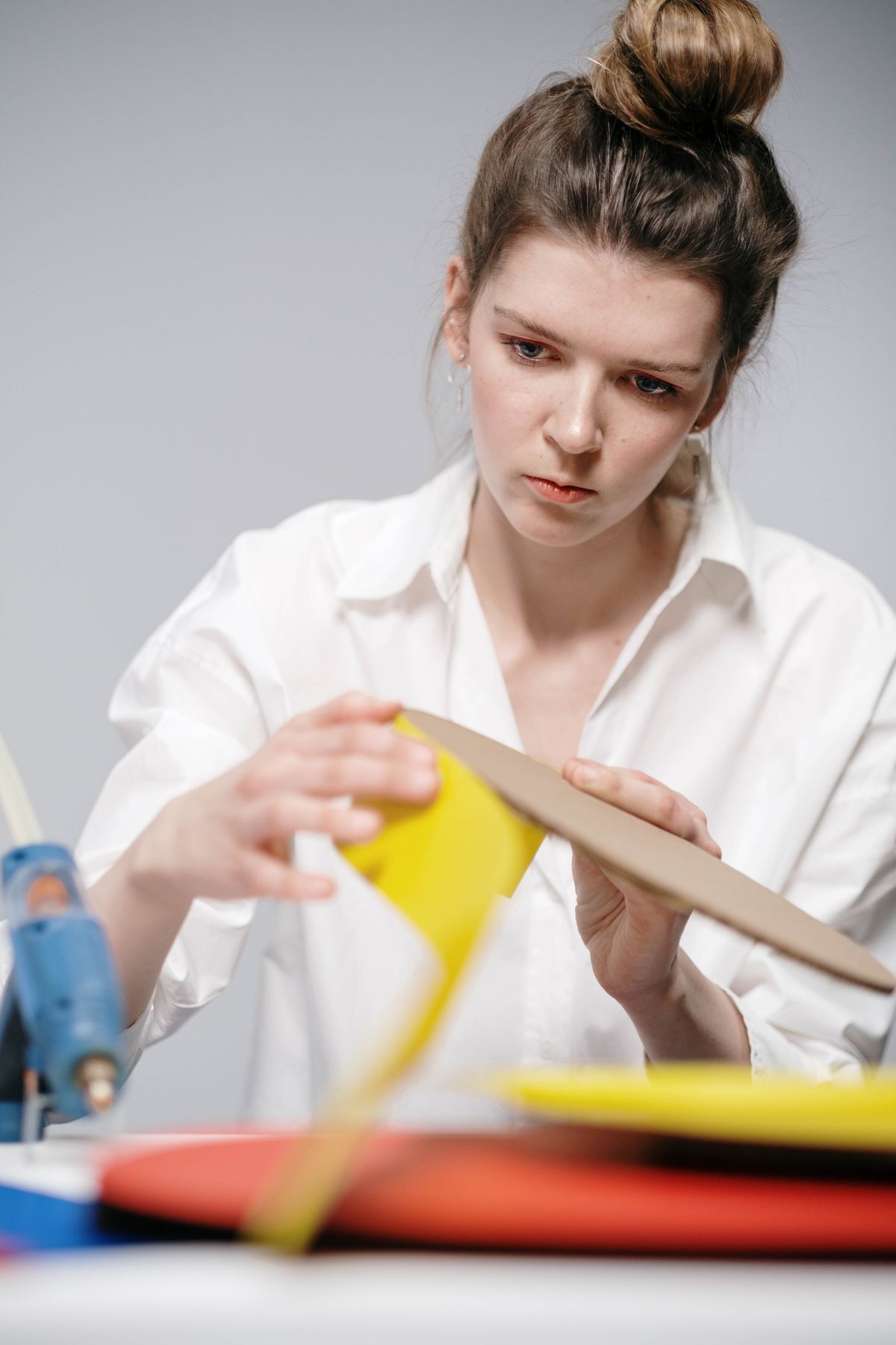 Young woman concentrating on building a cardboard dollhouse project