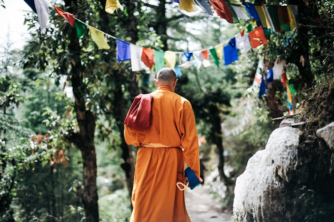 Free Monk Walking Near Buntings during Day Stock Photo
