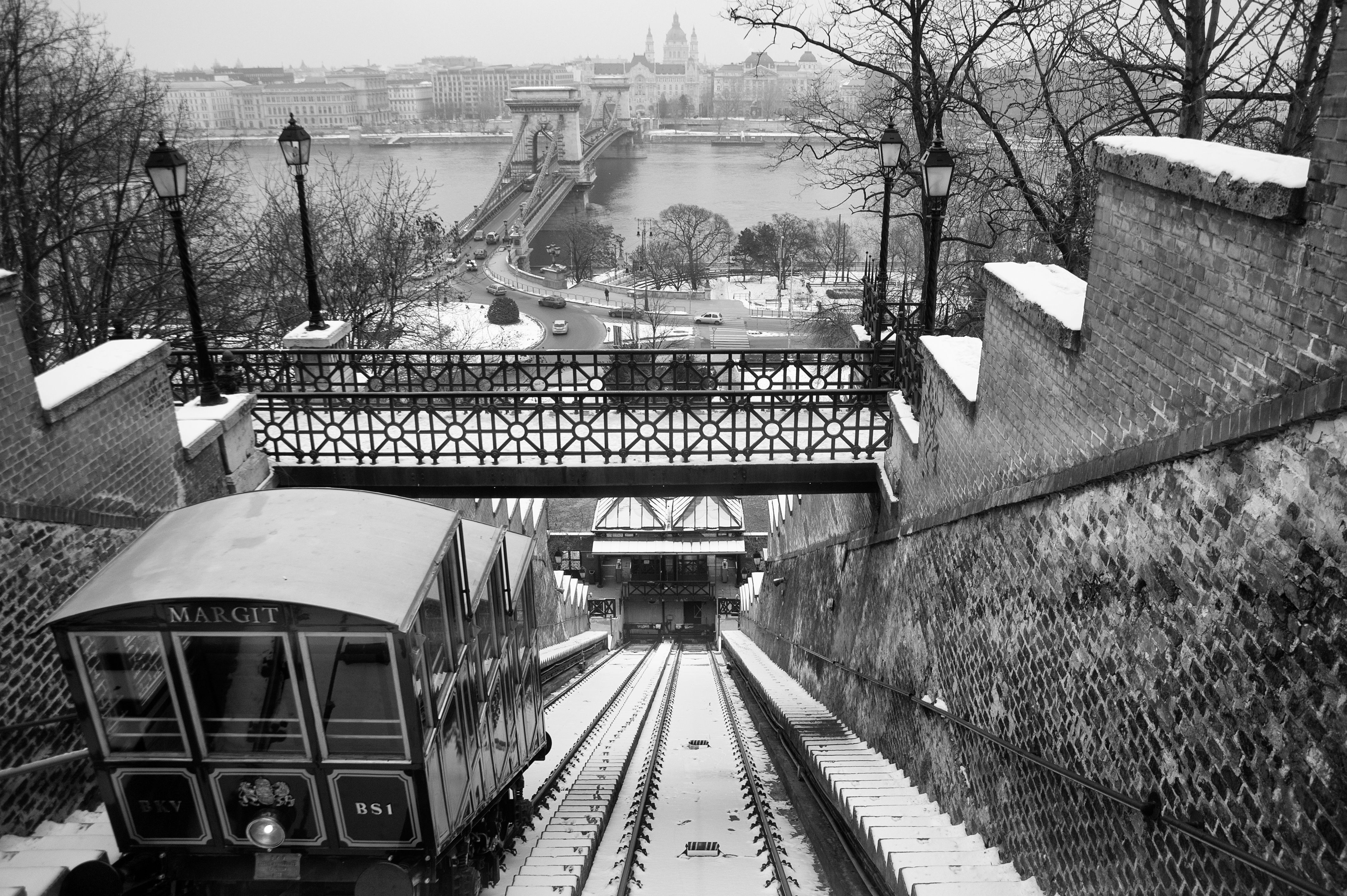Historic Budapest funicular with Chain Bridge in snowy winter setting.