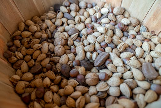 A close-up view of a variety of nuts in a wooden basket, showcasing textures and shapes.