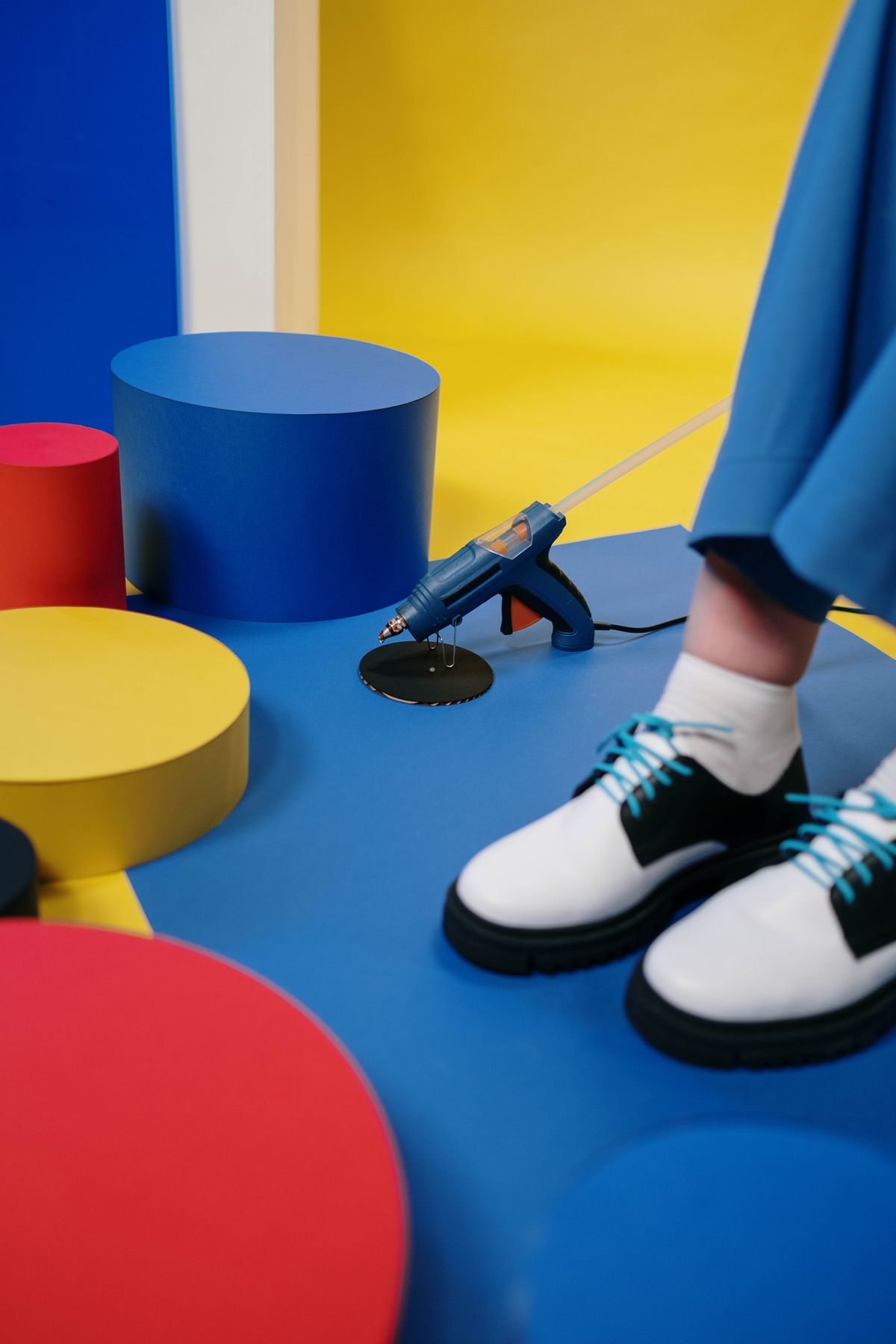 Creative studio scene with a glue gun and colorful geometric shapes for wall art