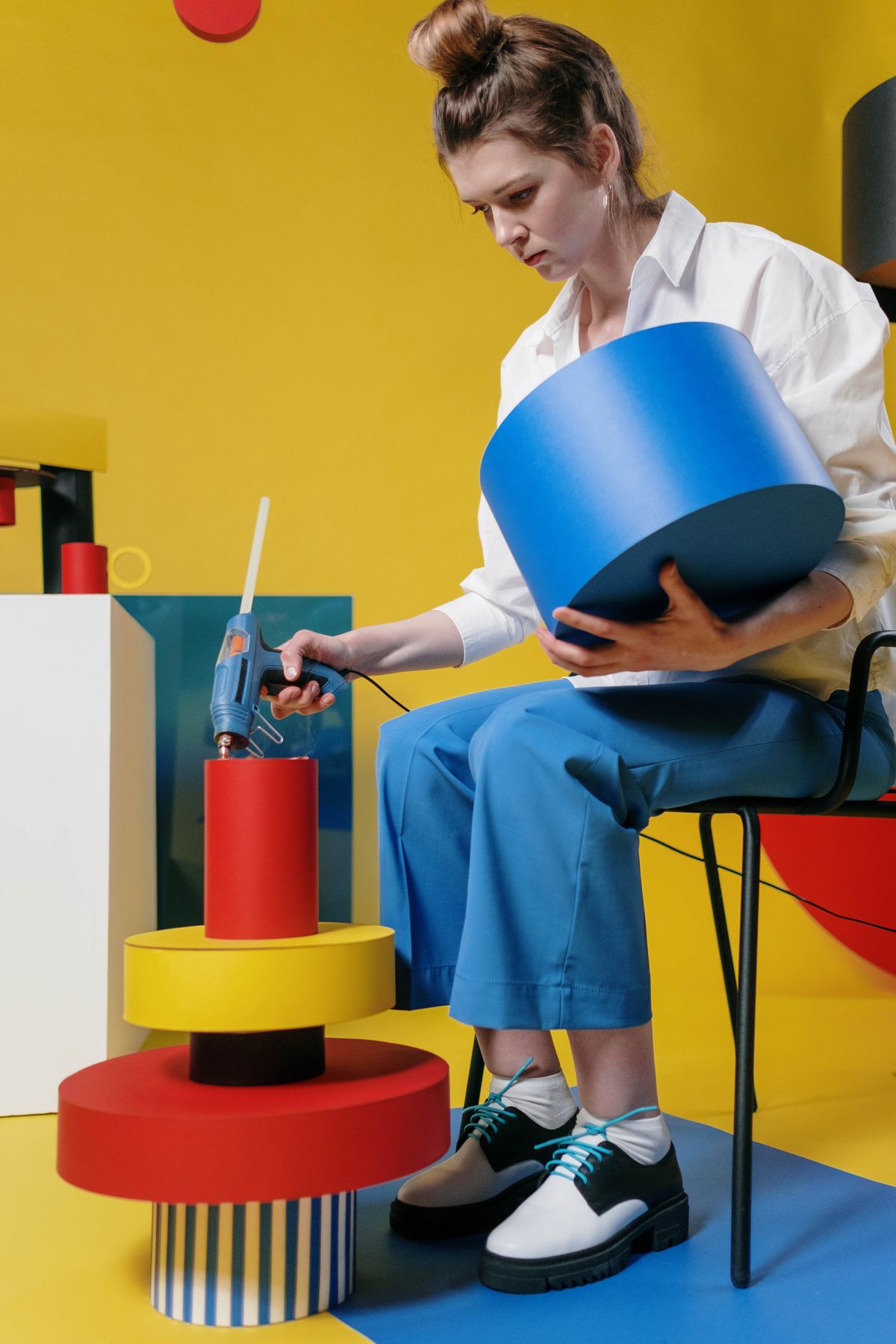 Woman crafting colorful geometric paper shapes for a hanging mobile