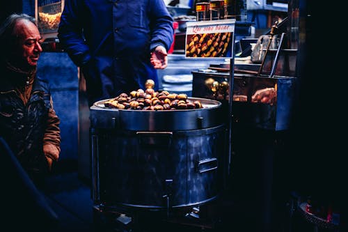 Man Sitting and Looking on Chestnuts