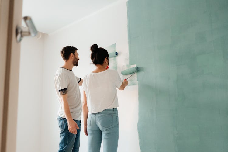 A Couple Painting The Wall