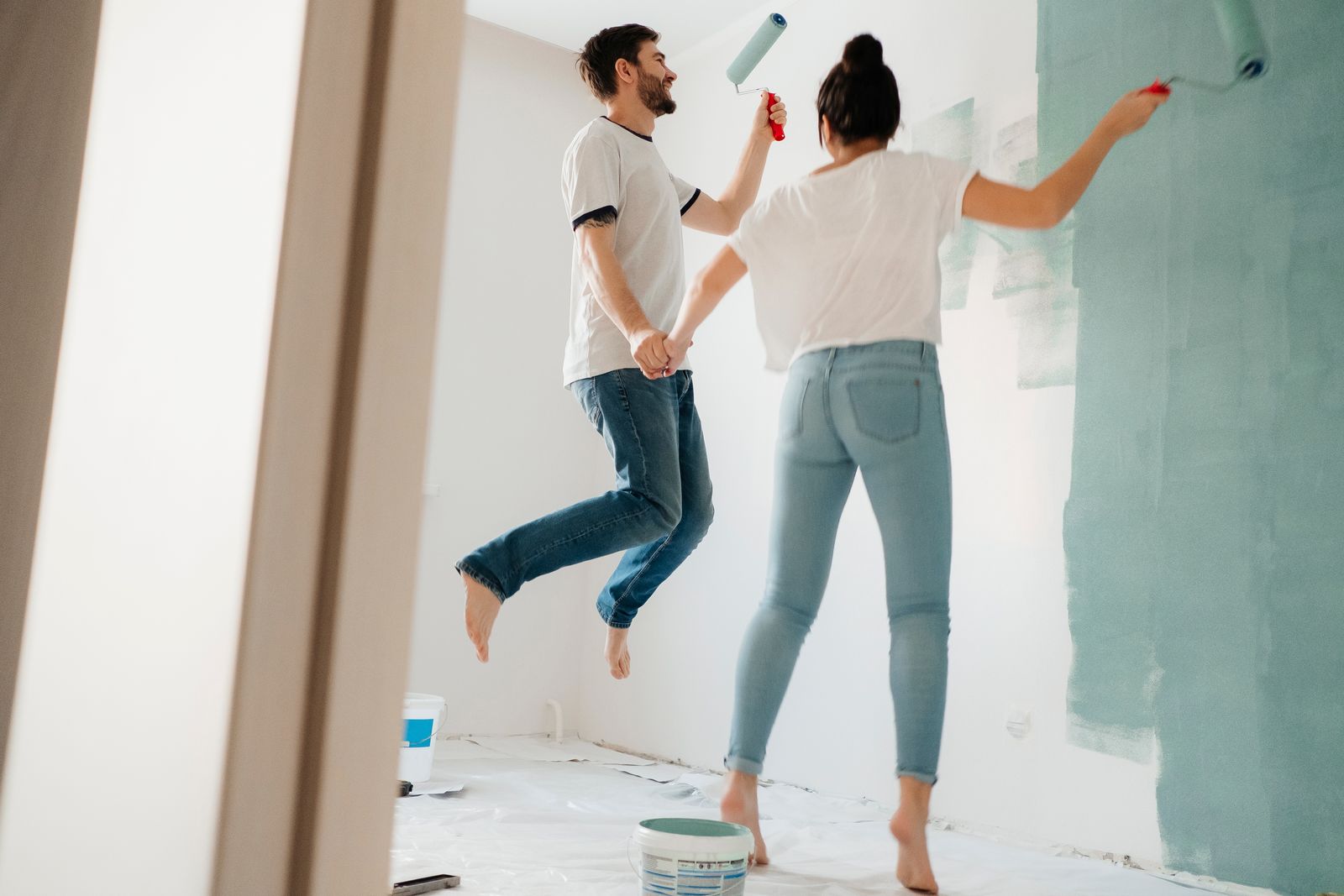 Walls being painted a soft neutral tone in a residential bedroom refresh