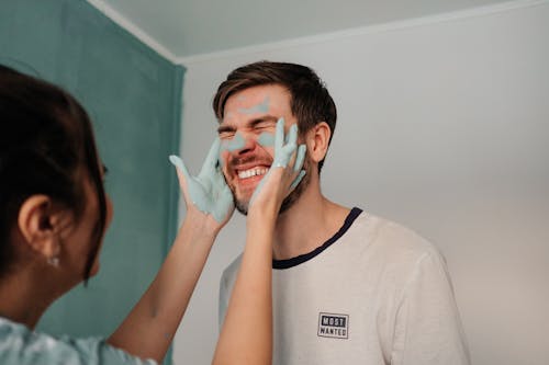 Free Woman with Paint on Her Hands Touching the Face of a Man Stock Photo