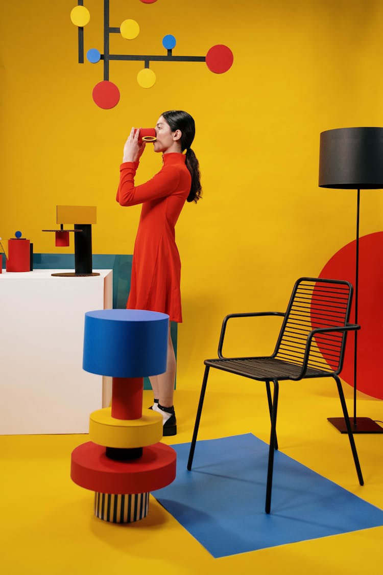 A Woman In A Red Dress Drinking From A Paper Craft Cup