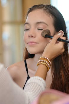 Close-up of a young woman receiving makeup in a beauty salon, capturing elegance and care.