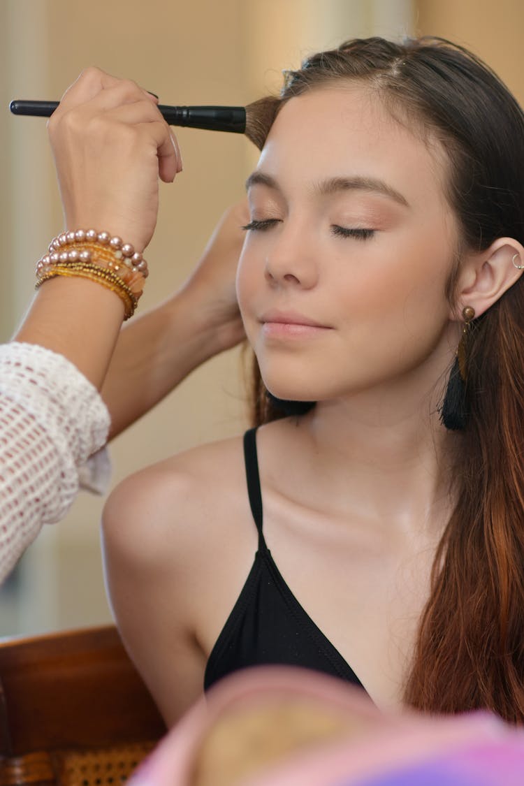 Woman Brushing Face With Foundation