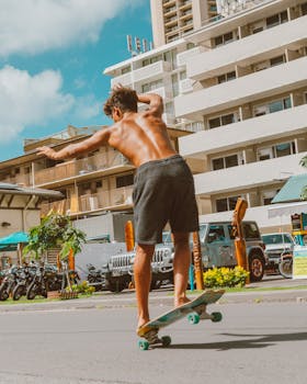 Vibrant image of a shirtless skateboarder doing tricks on a city street under a clear sky.