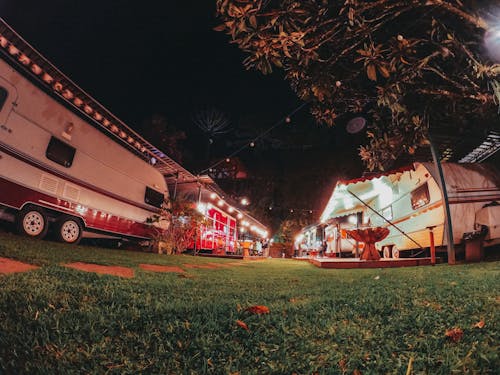 Illuminated caravans parked at campsite at night