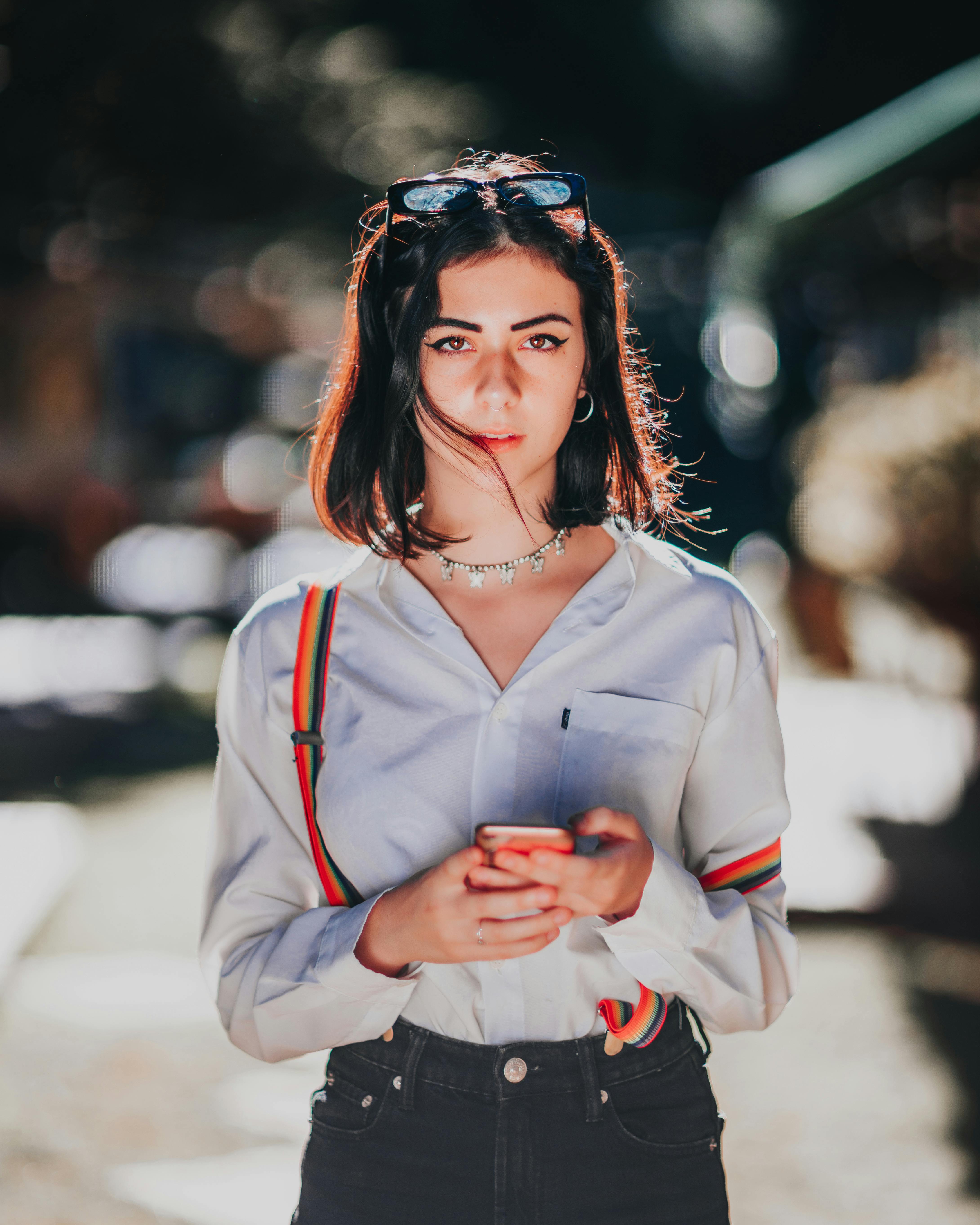 focused young ethnic lady with browsing smartphone on street