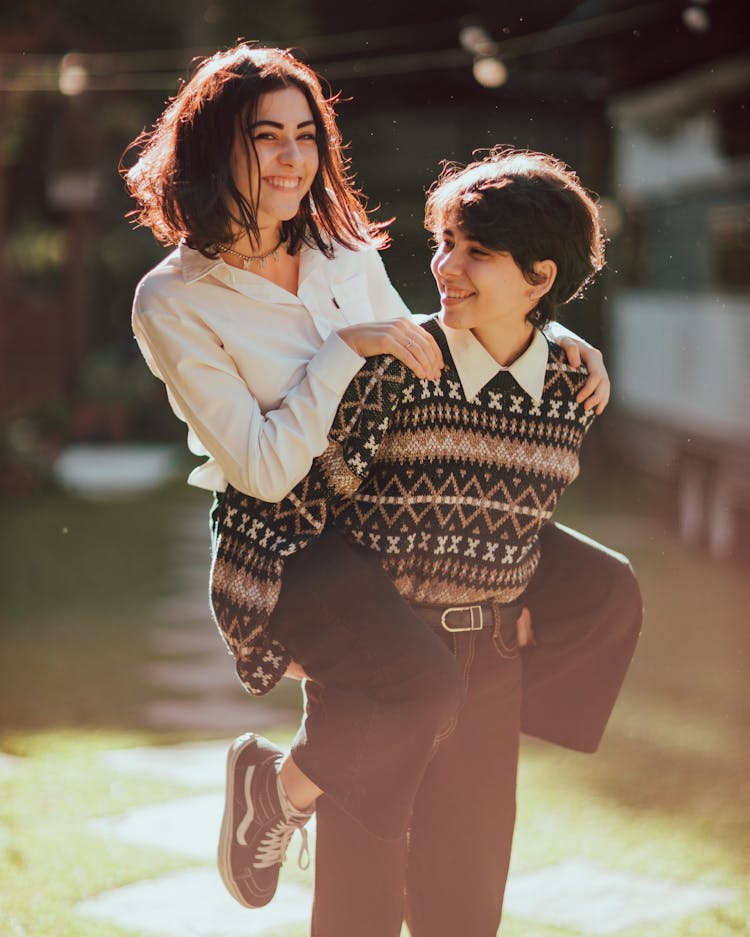 Smiling Woman Having Piggyback In Backyard