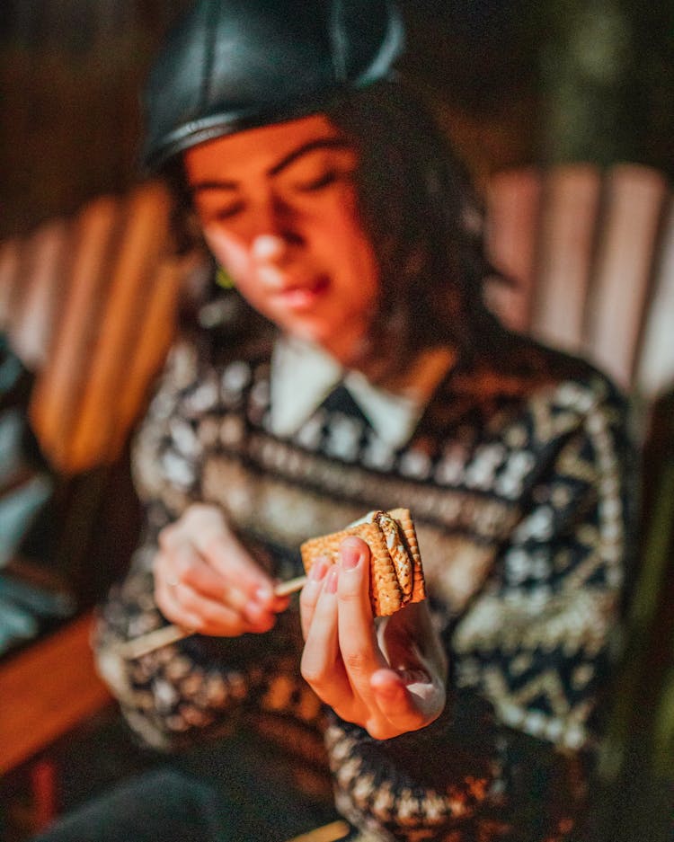 Woman Preparing Smore In Armchair At Dusk