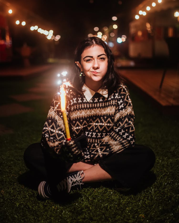 Woman Sitting With Sparkler Candle