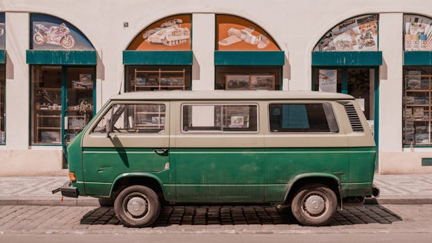 Retro green van parked in front of a shop on a sunny day in Prague, Czech Republic.