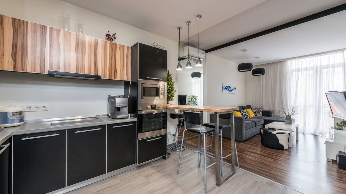 A modern studio apartment with a compact kitchenette and dining area