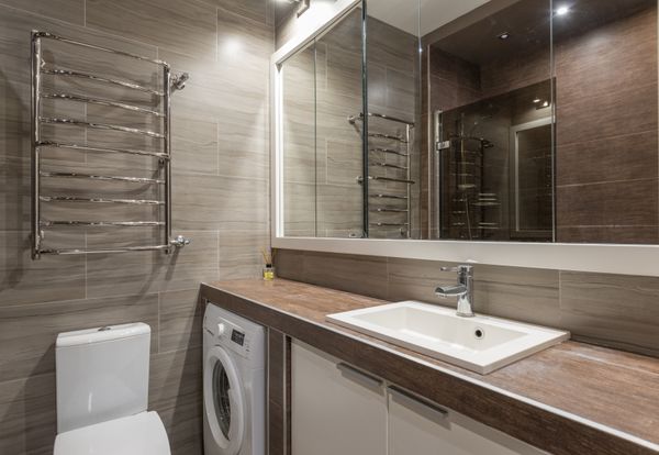 Baño con pared alicatada y espejo grande