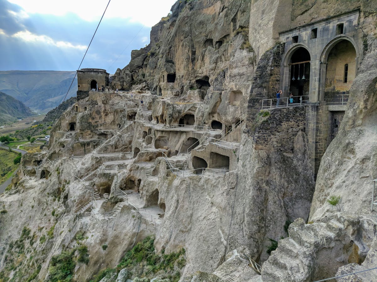 Person refinishing a wooden dresser with sanding and painting tools on a workbench
