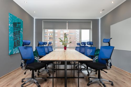 Free Armchairs at table with green plant placed near wall with creative signboard in modern conference room with window in office Stock Photo