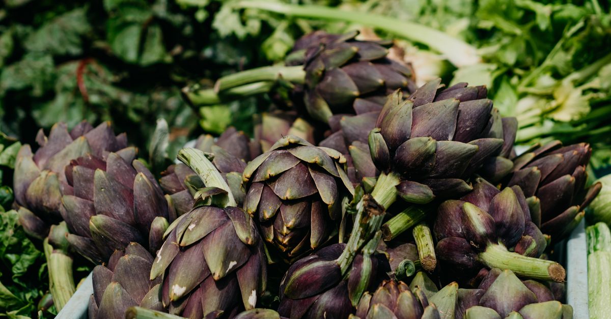 Fresh organic artichokes displayed at a farmers market, vibrant and healthy. - Evidence evidence guide for artichoke cholesterol meta-analysis