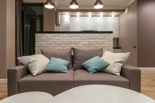 Modern living room featuring a cozy gray sofa and stylish cushions under warm lighting.
