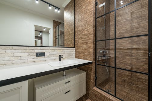Interior design of modern bathroom with shower cabin with chrome faucet and sink with pedestal and mirror on wall