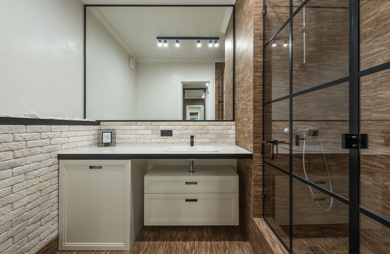 Track lighting with six spot heads reflected in a bathroom mirror