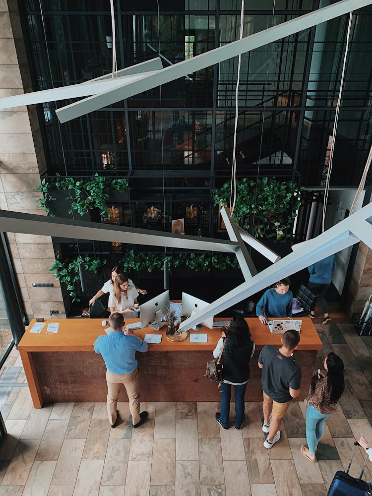 High Angle View On People At The Reception Desk In A Hotel 