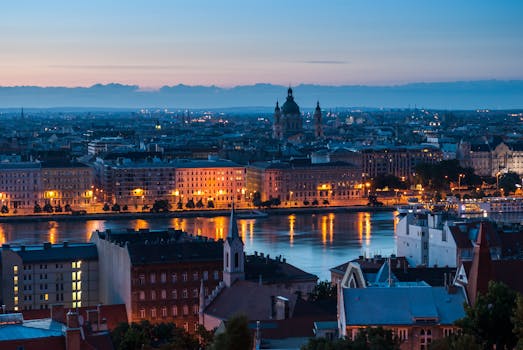 Stunning night view of Budapest's skyline along the Danube River with illuminated buildings.