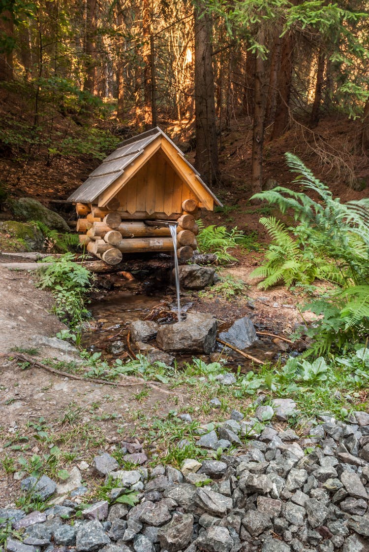 Water Flowing From A Wooden And Log Shelter