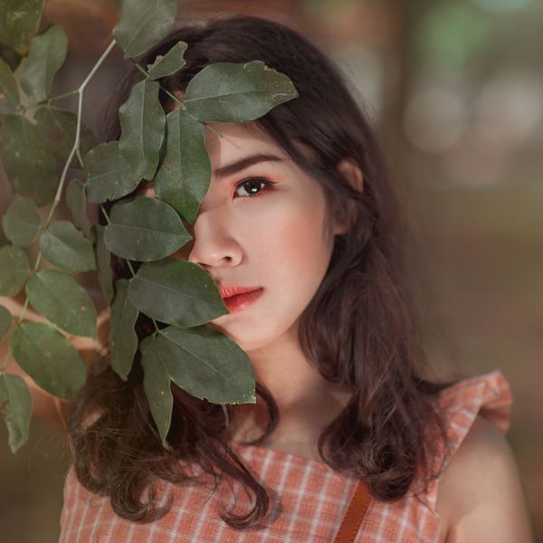 Portrait behind eucalyptus leaves, photo by Min An on Pexels