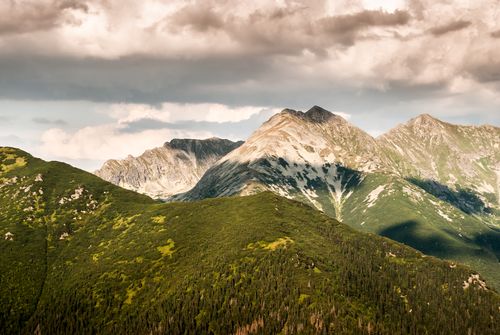 Free Scenic view of a lush mountain range with dramatic clouds in the sky, ideal for nature lovers. Stock Photo