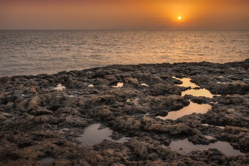 View of the Beautiful Sunset From a Rocky Shore
