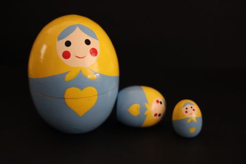 Free Close-up of traditional wooden Matryoshka dolls with vibrant colors against a black background. Stock Photo