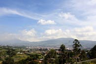 印度尼西亚伦邦的高清风景，蓝天映衬下是郁郁葱葱的绿色植物和山脉