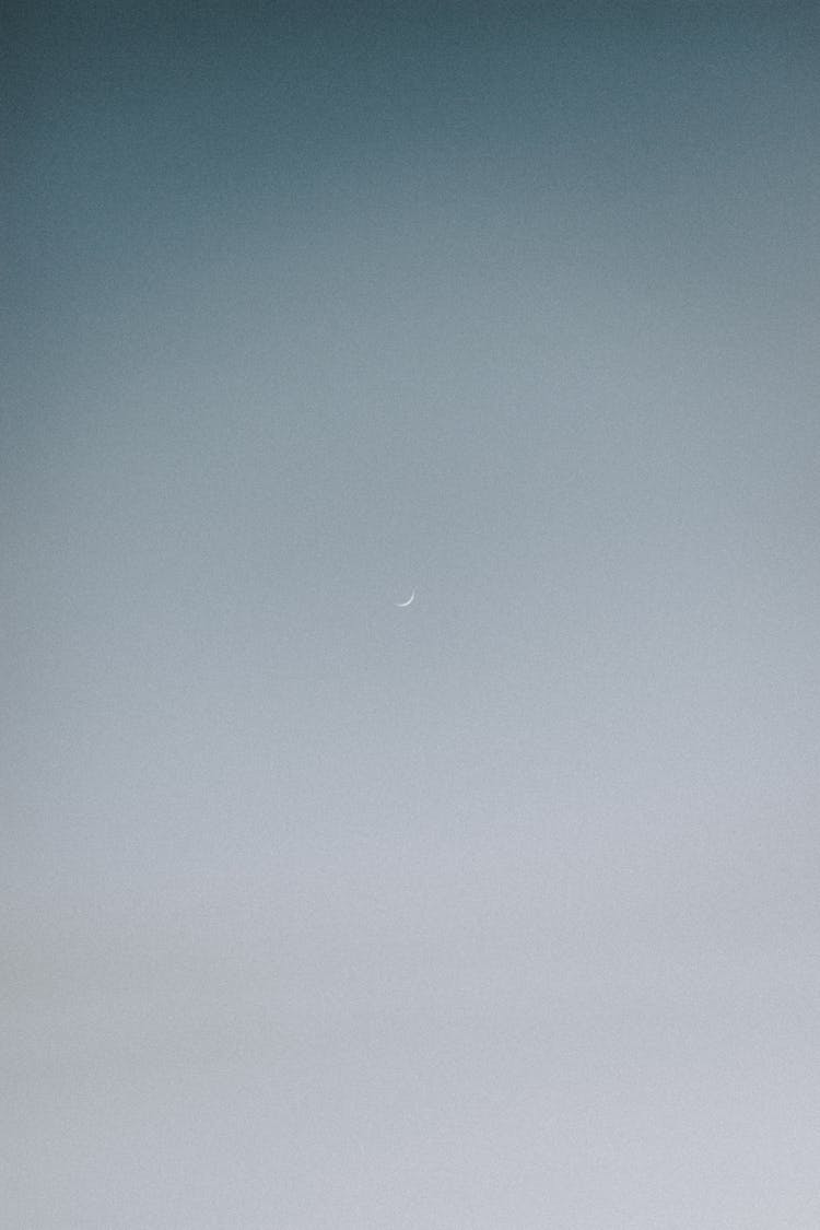 Small Crescent Moon In Light Gray Sky