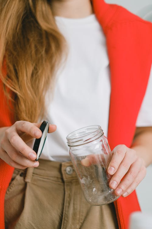 Woman with empty glass jar and lid