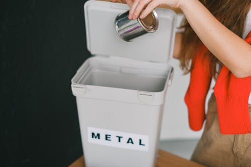Free Woman sorting garbage and putting metal can into bucket Stock Photo