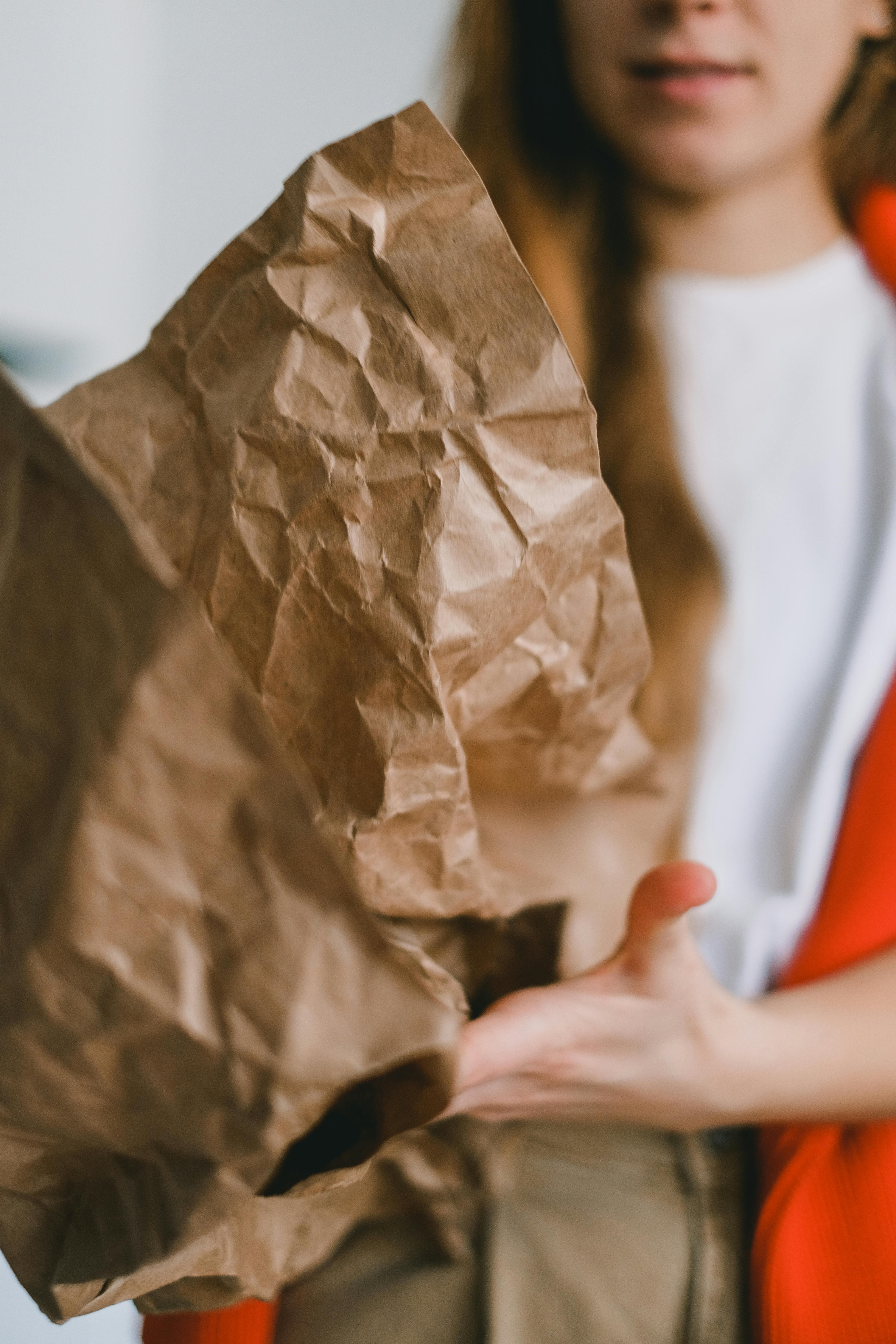 woman with crumpled paper sorting garbage