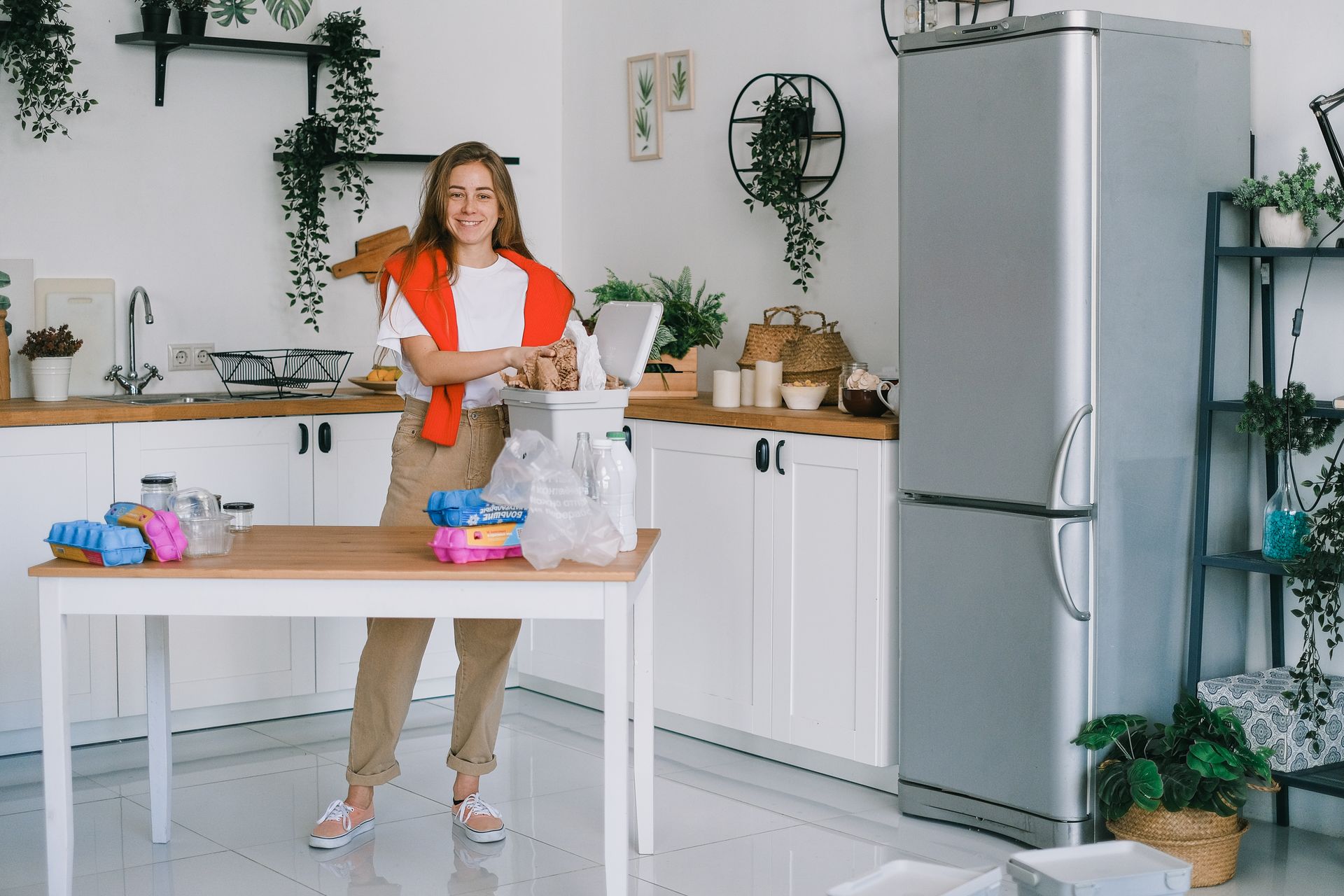 Young woman sorting waste in kitchen