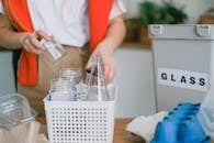 Woman selecting glass into plastic container