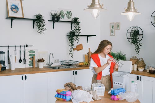 Young woman utilizing wastes in modern kitchen