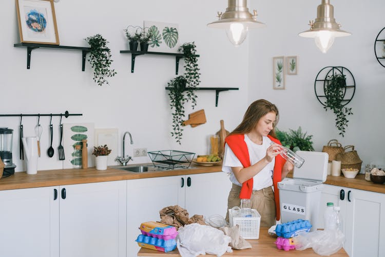 Young Woman Utilizing Wastes In Modern Kitchen