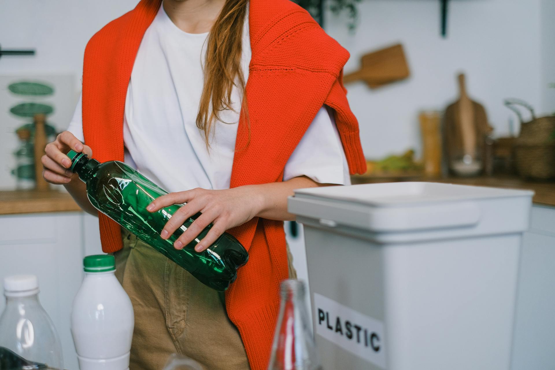 Female sorting plastic bottles at home