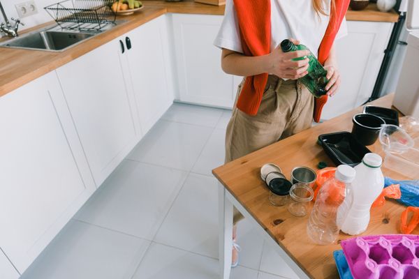 Woman sorting household waste in a kitchen