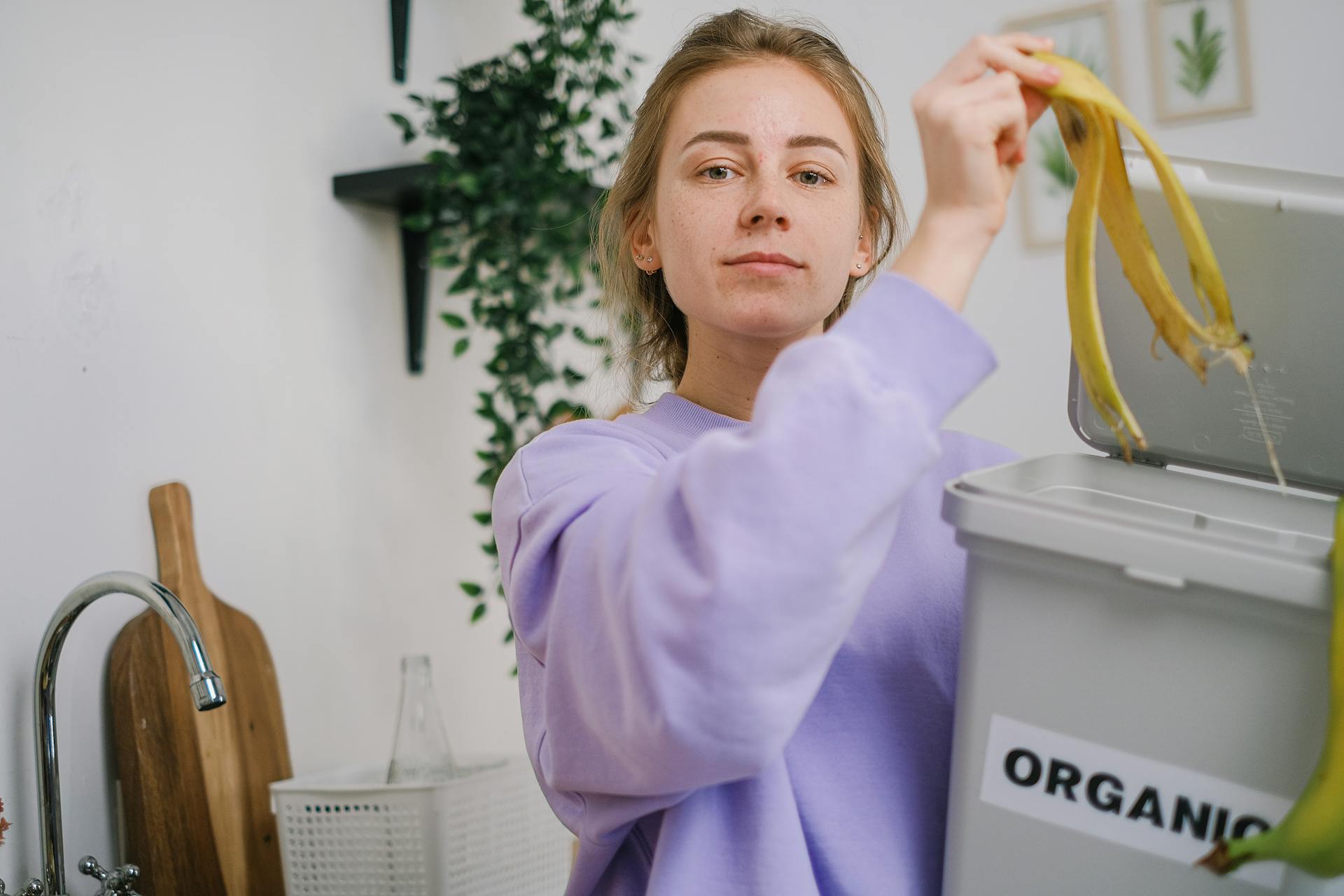 Woman Throwing a Banana Peel Inside a Organic Bin