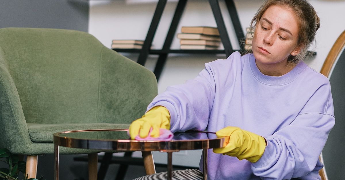Female squatting down and wiping table in light room · Free Stock Photo
